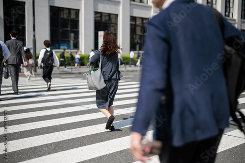 走って横断歩道を渡る働く女性 © paru