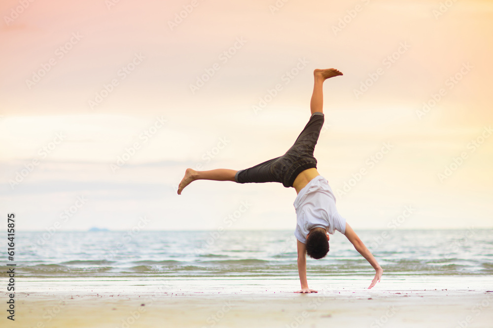 Teenager doing calisthenics exercise. Beach yoga. Teenager doing calisthenics exercise. Beach yoga.