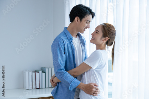 Young couple watching tv series laughing happily using tablet and sitting on sofa bed  © Sathit Trakunpunlert