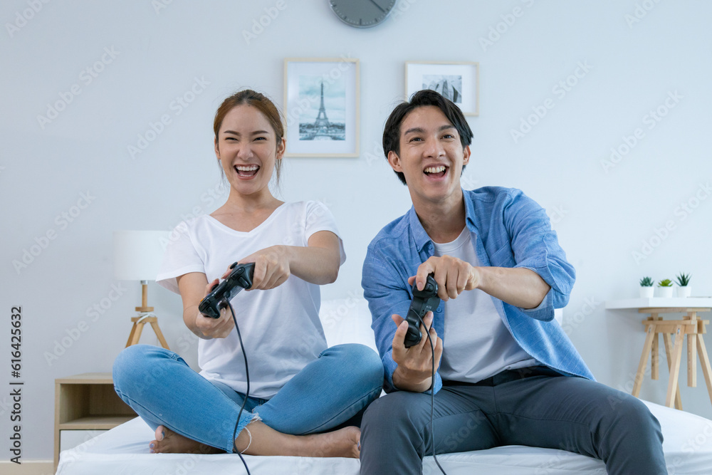 Happy couple holding hands playing pc game with joystick console It was a fun night. Happy couple holding hands playing pc game with joystick console It was a fun night.
