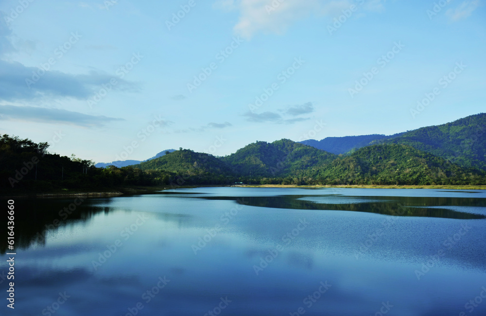 Beautiful view of water and mountain in good day. Blue scene on water surface isolated with mountain and beauty sky. Nature beauty concept.