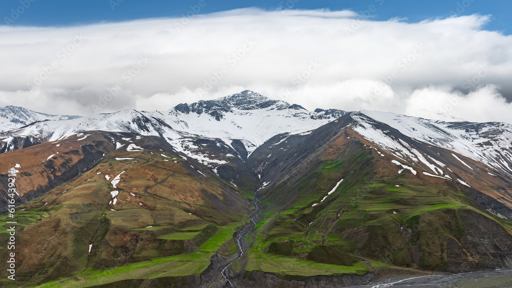 Mountain peaks covered with snow and thick clouds Mountain peaks covered with snow and thick clouds