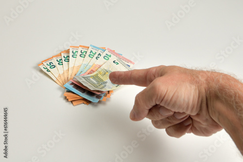 mano señalando al dinero como símbolo de poder