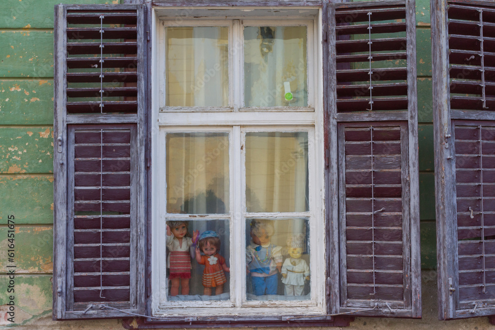 Φωτογραφία Vintage dolls in an old wooden window on the street of Sibiu