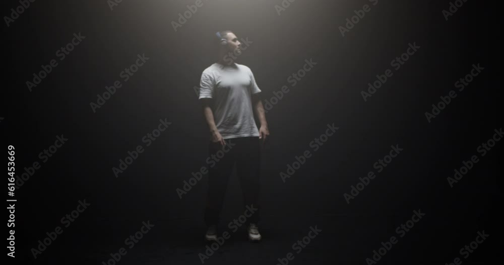 Cool man walking in spotlight and looking up Cool man walking in spotlight and looking up