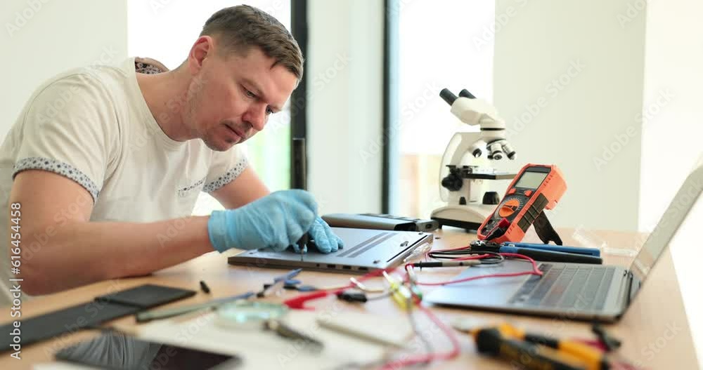 Laptop repair testing and computer service. Laptop cooler repairman with screwdriver