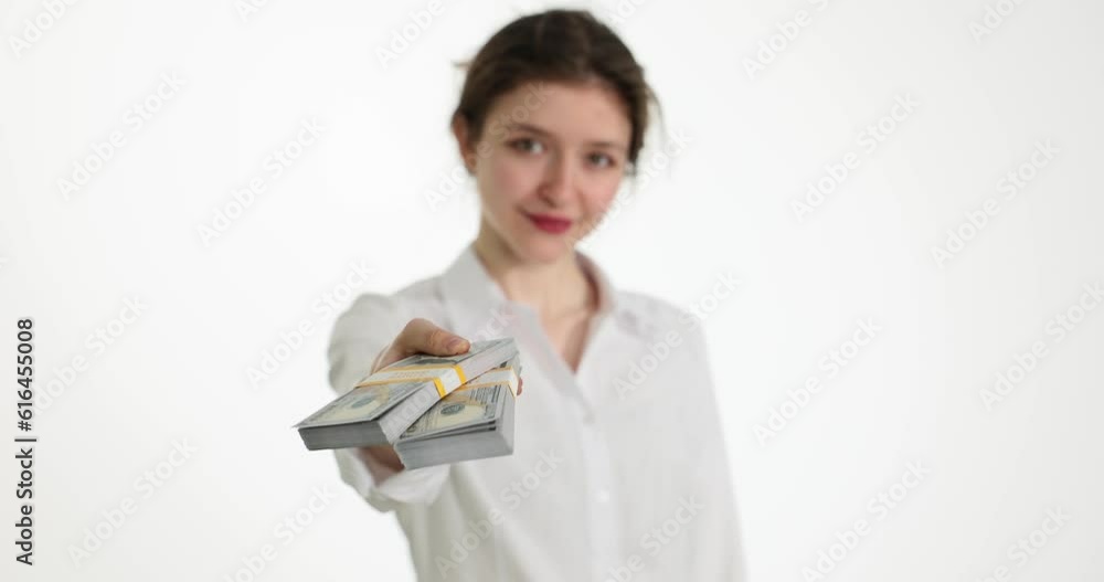 Smiling woman gives stack of dollar bills to client. Offering a bribe or financial investment Smiling woman gives stack of dollar bills to client. Offering a bribe or financial investment