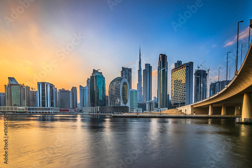 Skyline of Dubai in the evening at sunset. High-rise buildings in the business and financial center of the Arab city in the Emirates. Skyscraper with the Burj Khalifa and reflection of the low sun © Marco
