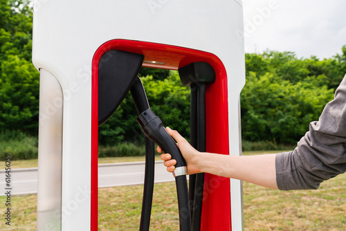 A man holds a charger plug for an electric car.
