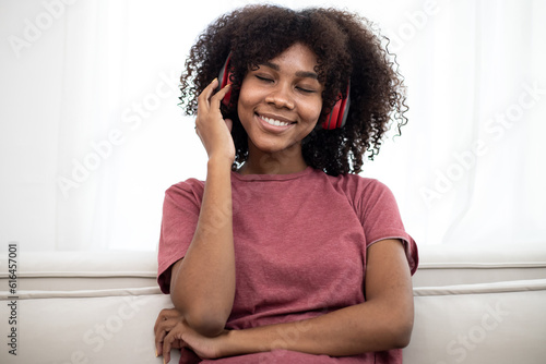 Above view of lovely African American lady taking selfie while listening to music in headphones at home. Listening and enjoying sound, audio podcast or song. Dreaming time.