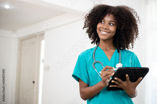 Beautiful hispanic doctor woman wearing stethoscope at the clinic happy face smiling with tablet computer looking at outside. Positive person. Home healthcare and Telehealth