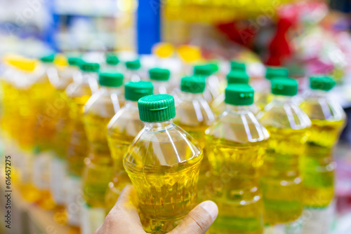 Plastic bottles of sunflower oil on shelf in supermarket, closeup