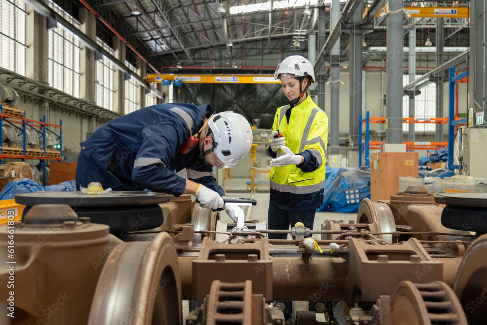 Two professional engineers checkmechanical check undercarriage of lifted electric train and maintenance of public transport trains in Asia Two professional engineers checkmechanical check undercarriage of lifted electric train and maintenance of public transport trains in Asia