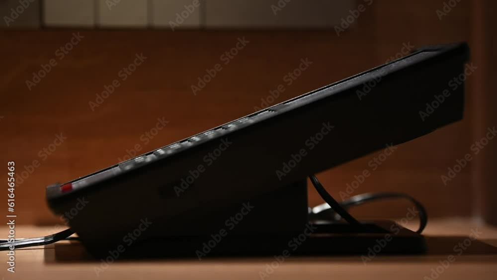 Close up of hotel guest pick up the phone holding and dialing phone numbers to hotel room services. Hotel phone services concept. Close up of hotel guest pick up the phone holding and dialing phone numbers to hotel room services. Hotel phone services concept.