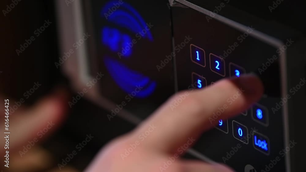 Man hand with a metal strongbox door close up. Unknown person entering numbers combination on electronic panel to lock modern safe. Male fingers pressing locker buttons using correct passcode. Man hand with a metal strongbox door close up. Unknown person entering numbers combination on electronic panel to lock modern safe. Male fingers pressing locker buttons using correct passcode.