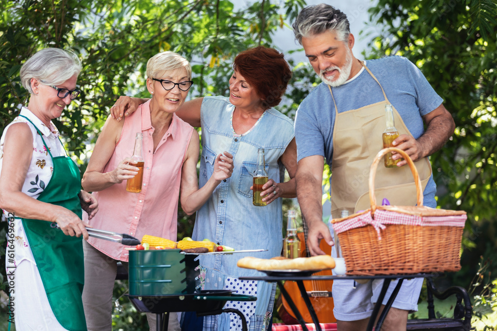 Obraz premium Elderly people celebrate the 4th of July by making barbeque in their backyard