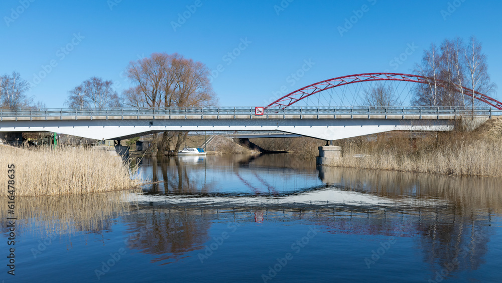 Fototapeta premium spring landscape with Ema river entering Lake Võrtsjärv in Estonia, bridge over river, reflections in calm river water