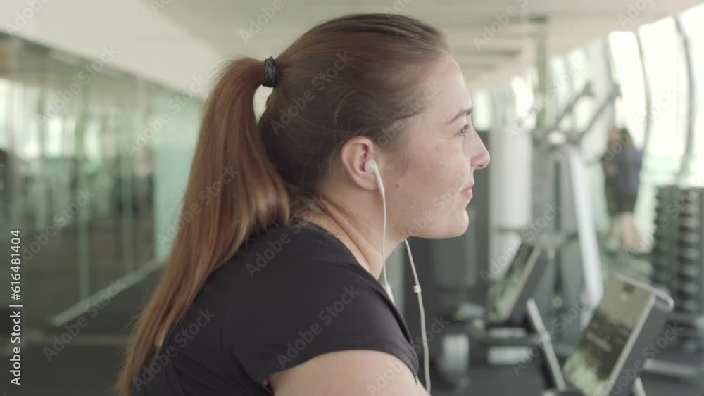 Plus size young happy woman doing workout on an exercise bike in the gym 4K Plus size young happy woman doing workout on an exercise bike in the gym 4K