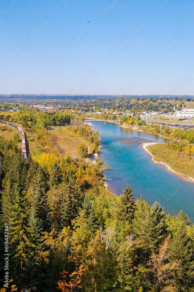 Autumn landscape in the city of Calgary showing the vegetation and the train passing by, showing the wooden walkways. Canadian autumn landscape showing vegetation and city structures such as a train.