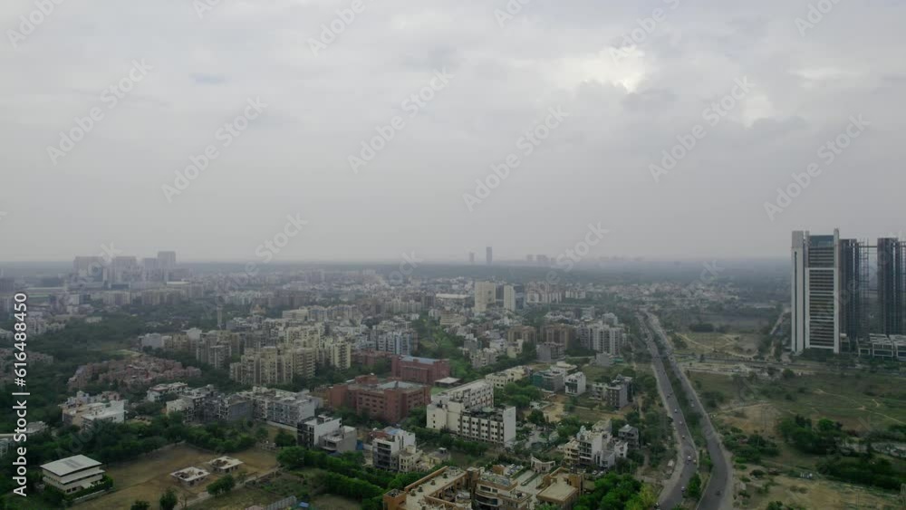 aerial drone shot on a cloudy overcast day showing cityscape of gurgaon with small houses, skyscrapers with homes houses, offies and shopping centers in the city of gurgaon delhi India aerial drone shot on a cloudy overcast day showing cityscape of gurgaon with small houses, skyscrapers with homes houses, offies and shopping centers in the city of gurgaon delhi India
