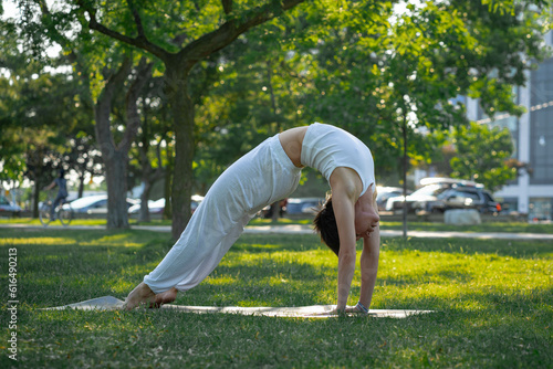 Sporty young Caucasian woman doing yoga practice concept of healthy life and natural balance between body and mental development outside in the Park