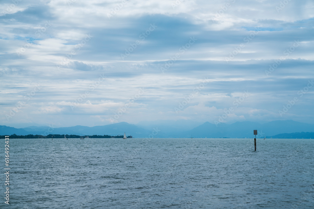 Germany, bodensee lake constance panorama view above water surface to alps mountains with rain and thunderstorm in summer