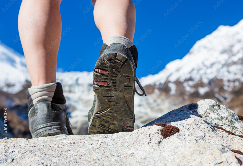 Hiking boots closeup on mountain rocks in Himalayas Hiking boots closeup on mountain rocks in Himalayas