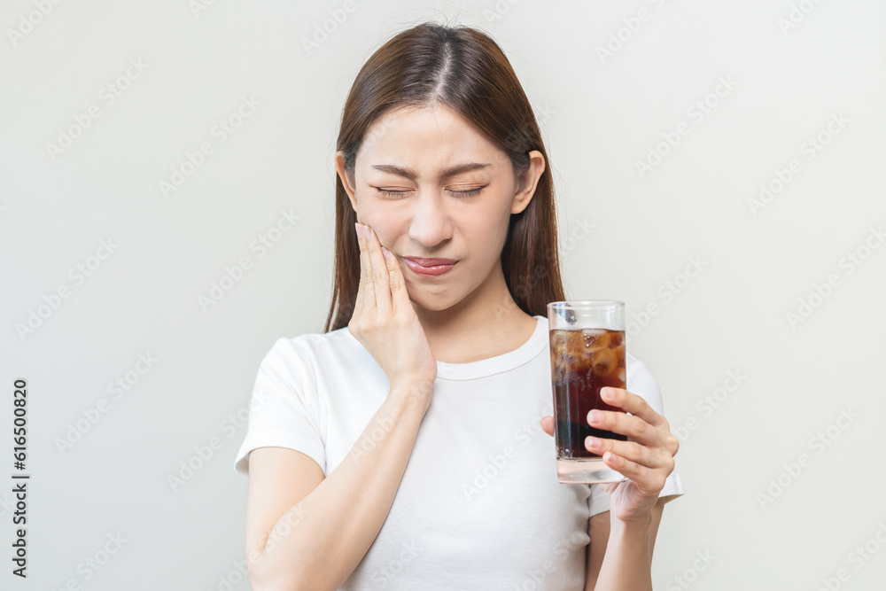 Health asian young woman touching her mouth, expression, suffering from toothache, decay or sensitivity cavity molar tooth or inflammation drink cold, sparkling water at home.Sensitive teeth people. Health asian young woman touching her mouth, expression, suffering from toothache, decay or sensitivity cavity molar tooth or inflammation drink cold, sparkling water at home.Sensitive teeth people.