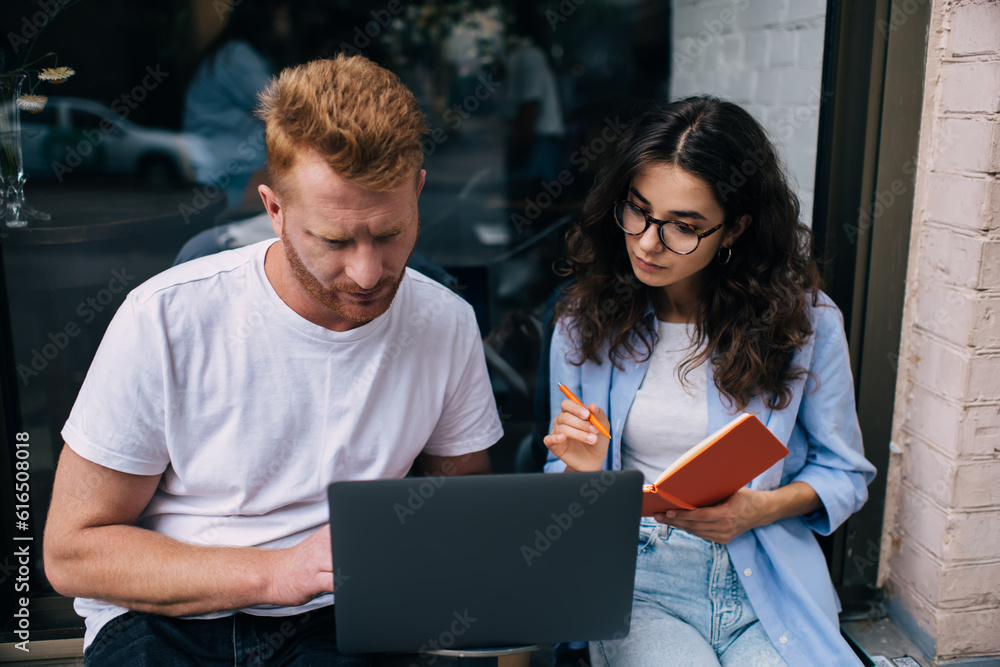 Focused couple using laptop in cafe Focused couple using laptop in cafe