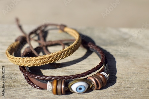 Linen, braided and leather bracelets for men on a wooden surface, everyday men's accessory.