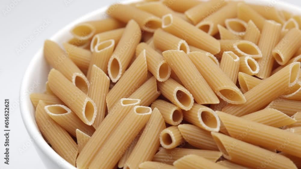 Penne Rigate. Raw Italian Pasta In A White Bowl. Rotating. 4k, 60 FPS, ProRes. Penne Rigate. Raw Italian Pasta In A White Bowl. Rotating. 4k, 60 FPS, ProRes.