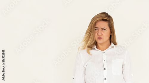 Billede på lærred Studio shot of cute girl with fair hair and confused face isolated on white back