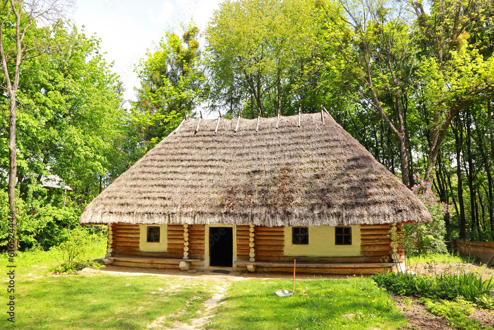 Wooden house with a thatched roof in skansen Museum of Folk Architecture and Life Wooden house with a thatched roof in skansen Museum of Folk Architecture and Life