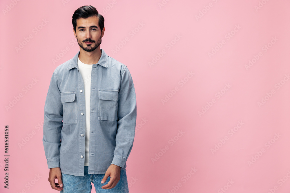 Portrait of a stylish brunette man with a beard beautiful smile on a pink background in a white T-shirt and jeans smile and joyful emotion on his face, copy space Portrait of a stylish brunette man with a beard beautiful smile on a pink background in a white T-shirt and jeans smile and joyful emotion on his face, copy space