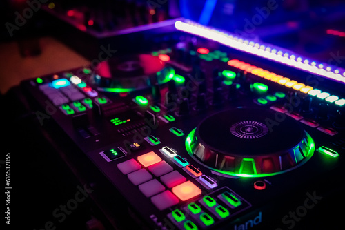 A cool DJ standing at the mixer controller, composing a new mix and making the party in a nightclub nightlife concept. dj concept. party concept