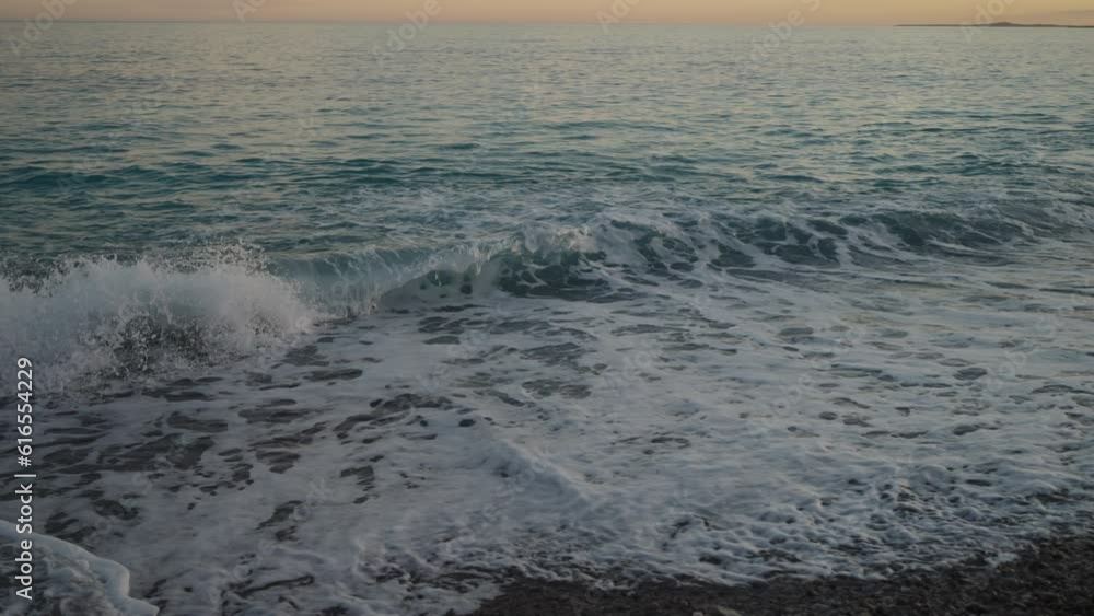 Slow motion sunset on pebble beach with sea waves of mediterranean sea Slow motion sunset on pebble beach with sea waves of mediterranean sea