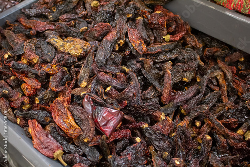 A view of a bin full of dried chile morita, on display at a local grocery store. photo