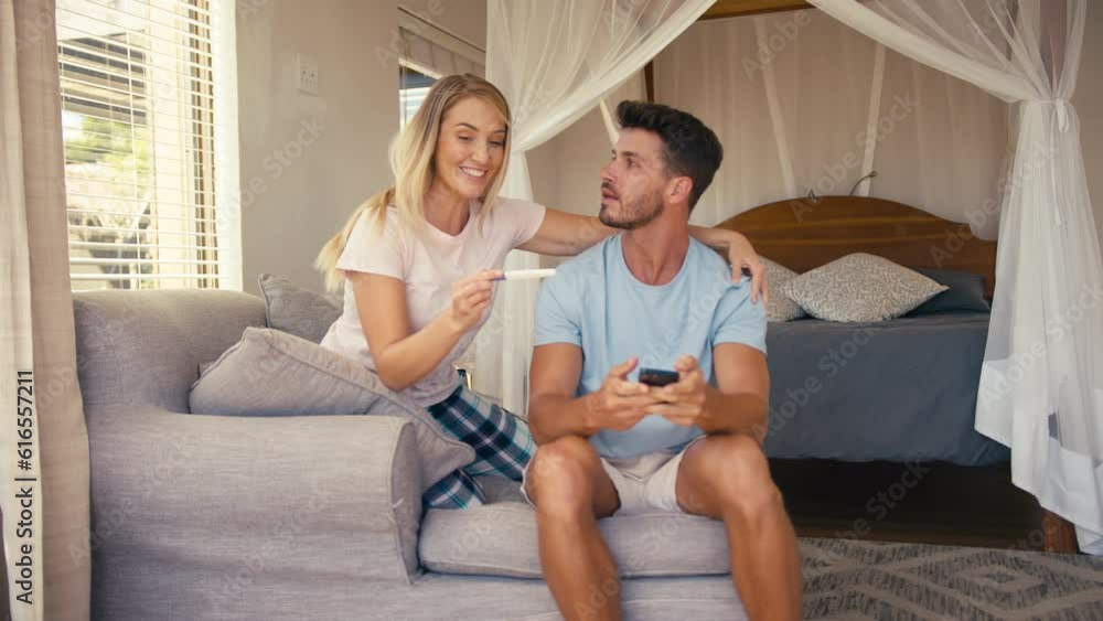 Excited couple in bedroom at home celebrating positive pregnancy test result - shot in slow motion Excited couple in bedroom at home celebrating positive pregnancy test result - shot in slow motion