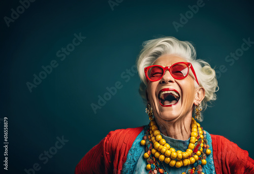 Photo of a happy elder woman with vibrant orange hair and stylish sunglasses © Nedrofly