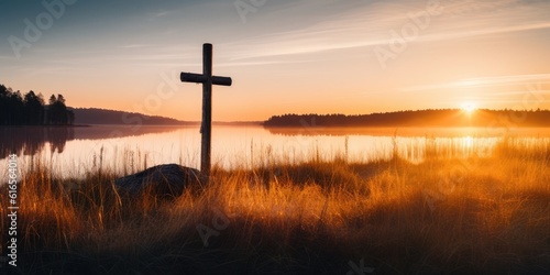 a cross in the grass by a body of water