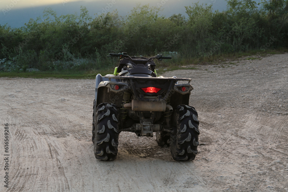 Modern fast quad bike on pathway outdoors Modern fast quad bike on pathway outdoors