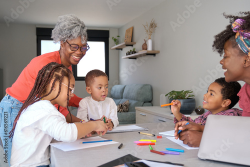 African mothers painting with their children during the freetime. Horizontal extended family.