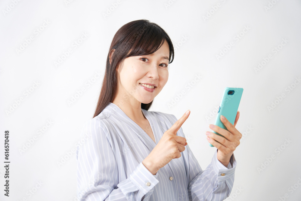 スマートフォンを使うミドルエイジ女性 白背景 カメラ目線 スマートフォンを使うミドルエイジ女性 白背景 カメラ目線