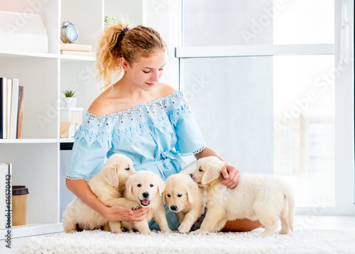 Nice girl and retriever puppies on light room