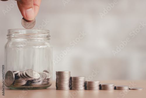 Saving finance business investment concept. Hand of male or female putting coins in jar with money stack step growing growth saving money. Investment And Interest Concept. photo