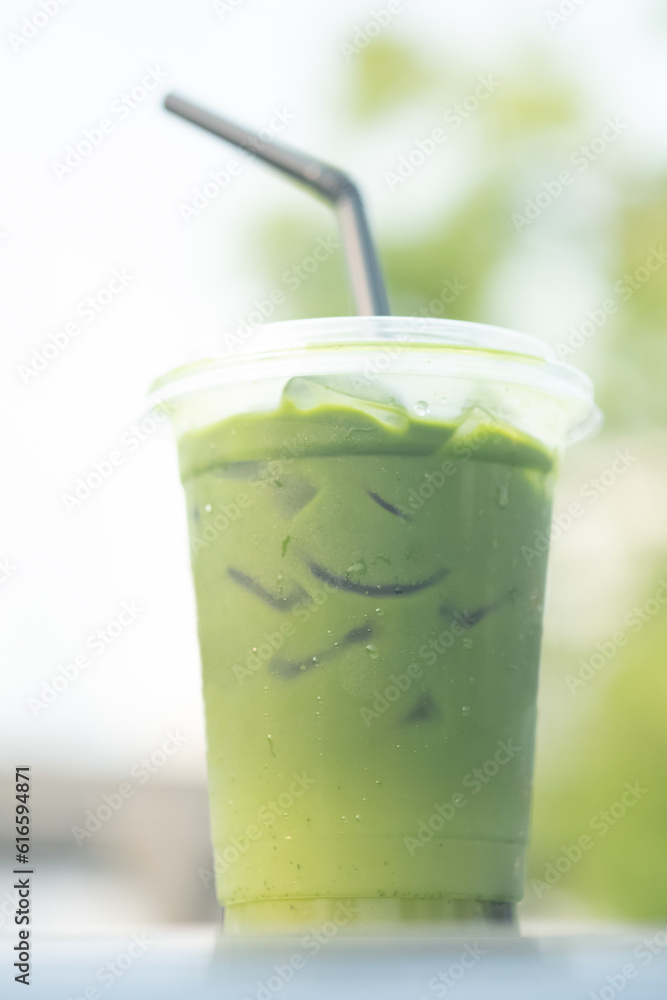 Iced matcha green tea in glass with nature background.