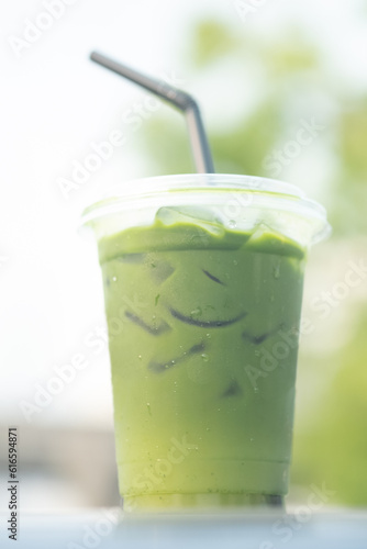 Iced matcha green tea in glass with nature background.