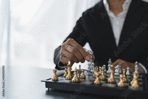 Investor playing chess board game conceptual image of businessman holding chess piece in business competition and risk management Plan a business strategy to beat your competitors. leadership concept