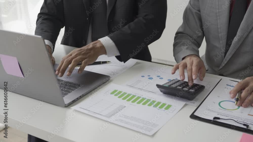 Asian male businessman with two financial advisers analyzing chart data in document Use files and documents to create on your laptop with colleagues working in Office 4K. Asian male businessman with two financial advisers analyzing chart data in document Use files and documents to create on your laptop with colleagues working in Office 4K.