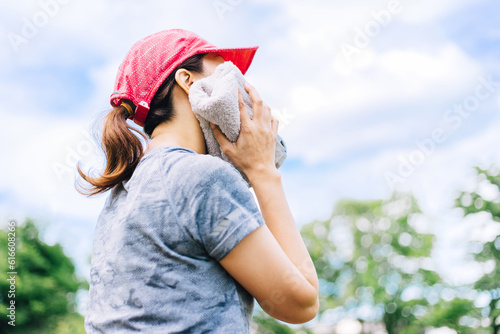 Fototapeta Naklejka Na Ścianę i Meble -  タオルで汗を拭くスポーツ中の女性